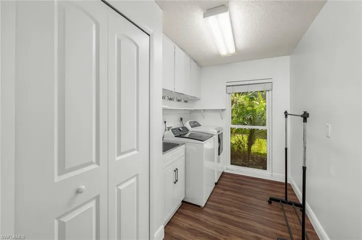 Inside Laundry room with sink, extra cabinets & pantry closet.