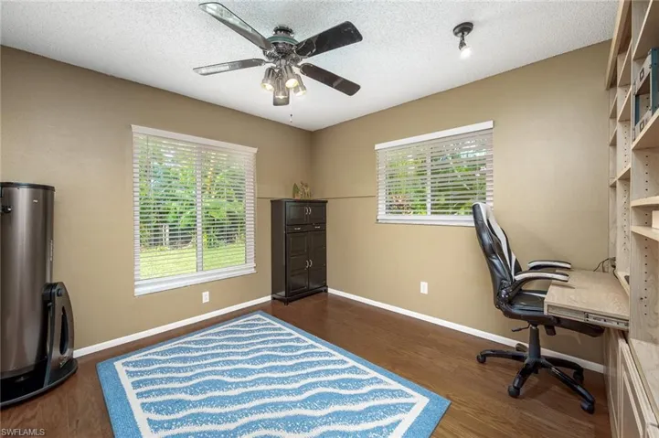 Bedroom with built in wall unit with desk, shelving and cabinets.