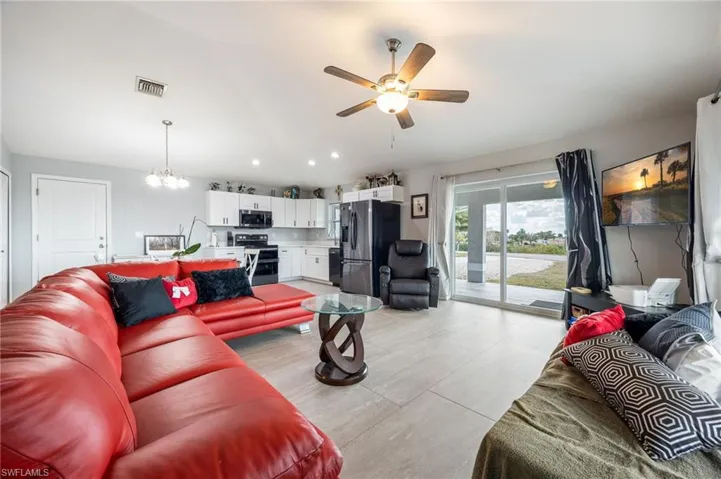 Living area featuring a chandelier, ceiling fan, lofted ceiling, and recessed lighting