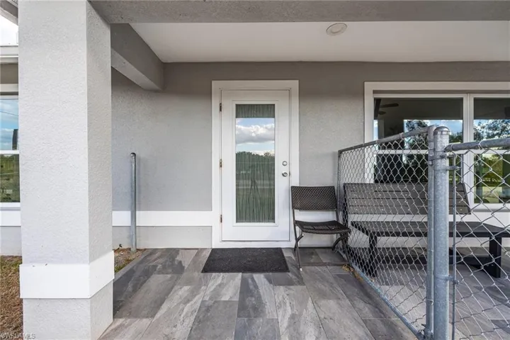 Entrance to property with stucco siding and a patio area