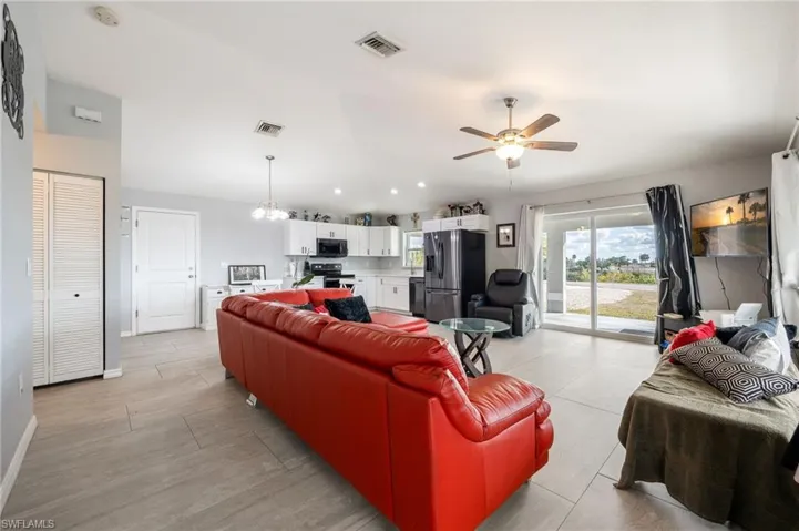 Living area featuring a chandelier, a ceiling fan, lofted ceiling, and recessed lighting