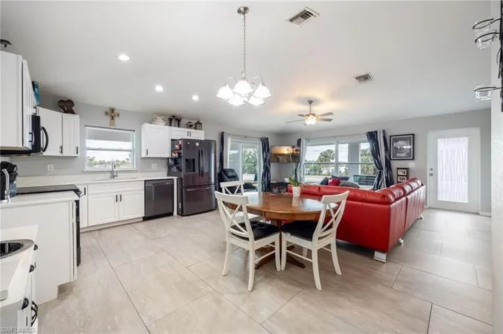 Dining area featuring a chandelier, a ceiling fan, recessed lighting, and light tile patterned floors