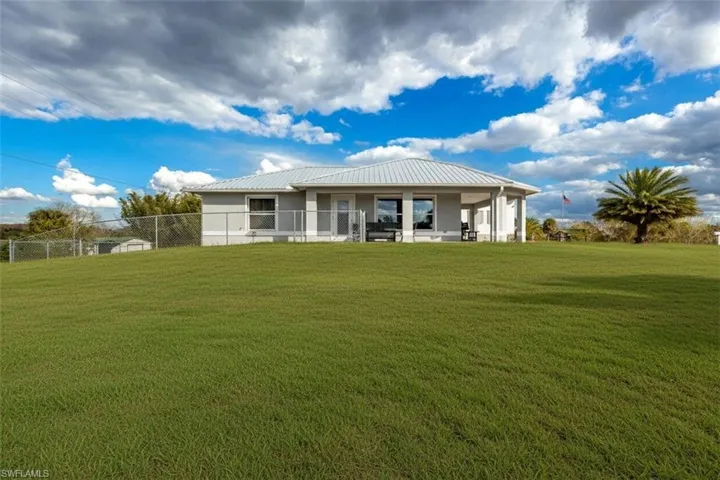 Back of house with a patio area and a metal roof
