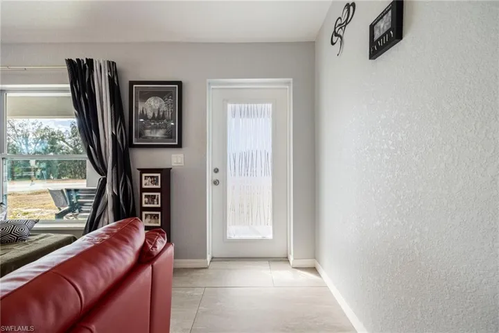 Tiled entryway featuring a textured wall