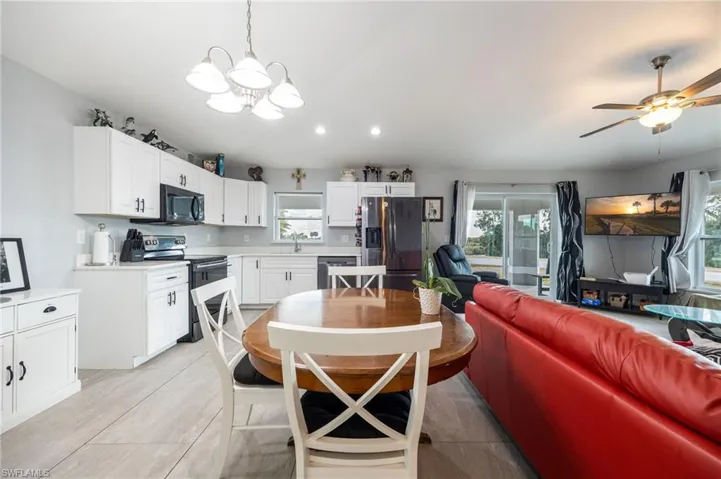 Dining area featuring lofted ceiling, a chandelier, ceiling fan, and recessed lighting