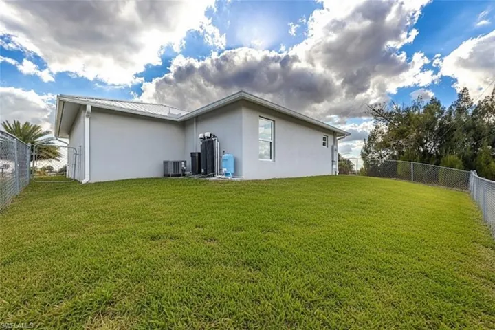 Rear view of house with a fenced backyard and stucco siding