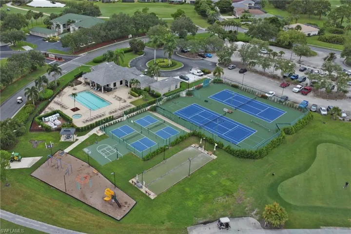Aerial view of property and surrounding area with a pool area and a golf course