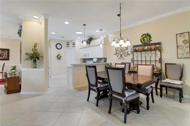 Dining area with crown molding, light tile patterned floors, a chandelier, and recessed lighting