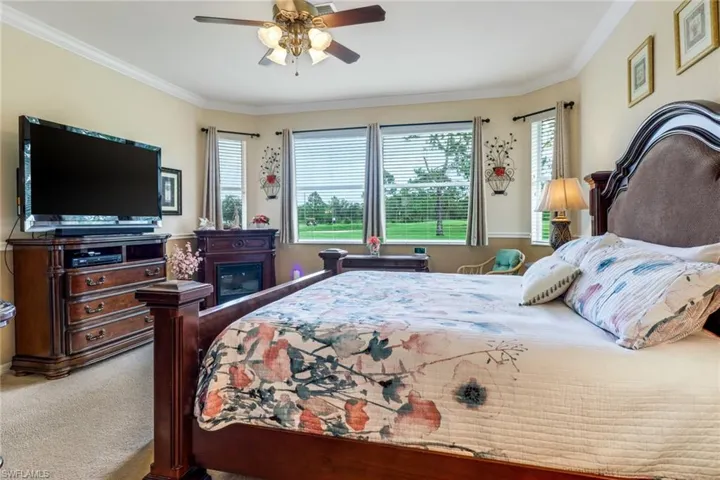 Bedroom featuring carpet flooring, crown molding, and a ceiling fan