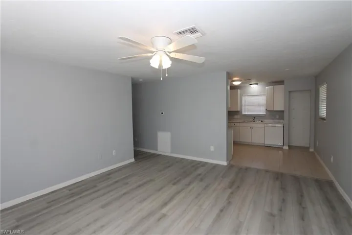 Unfurnished living room featuring sink, light hardwood / wood-style floors, and ceiling fan