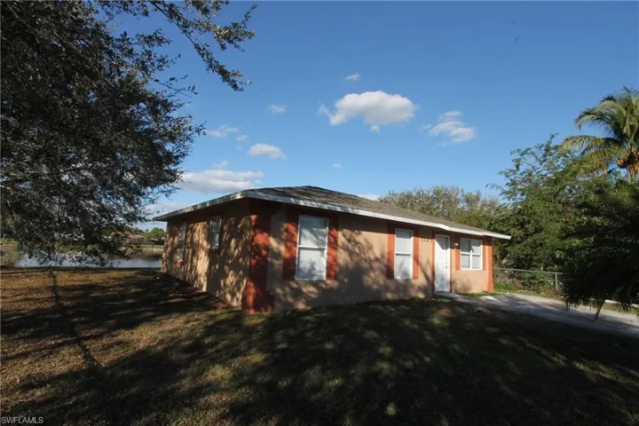 View of property exterior featuring a yard and a water view