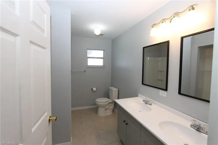 Bathroom featuring vanity, toilet, and tile patterned flooring
