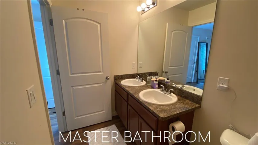 Full bath with double vanity and toilet