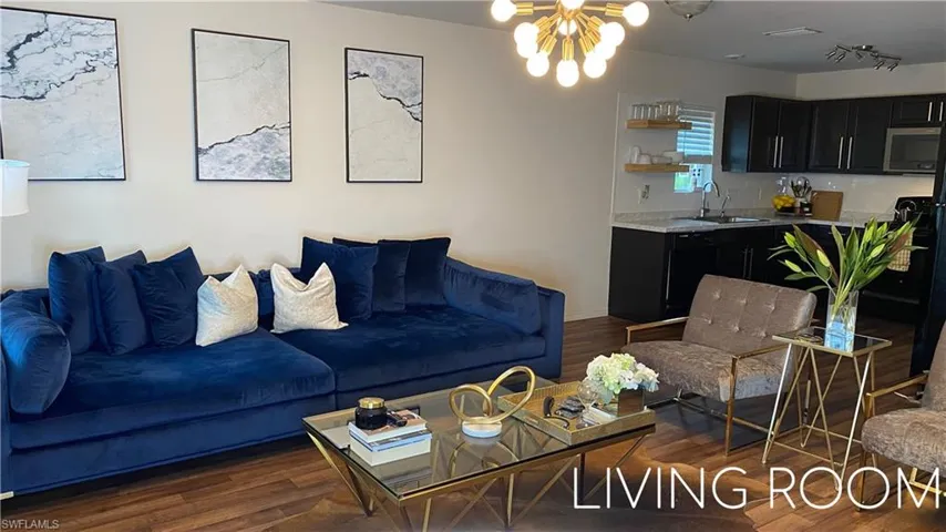 Living room featuring suspended lighting and dark wood finished floors