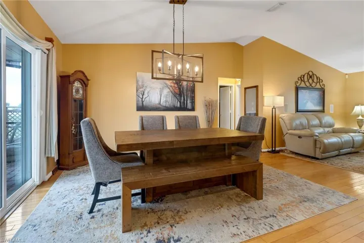 Dining space with lofted ceiling, a chandelier, and light hardwood / wood-style floors