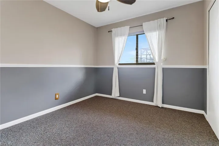 Unfurnished room with ceiling fan and carpet