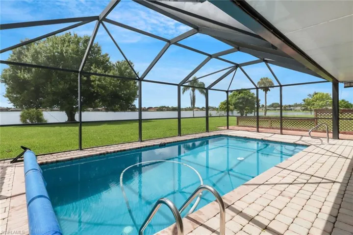 View of swimming pool with a patio area, a lawn, and a lanai