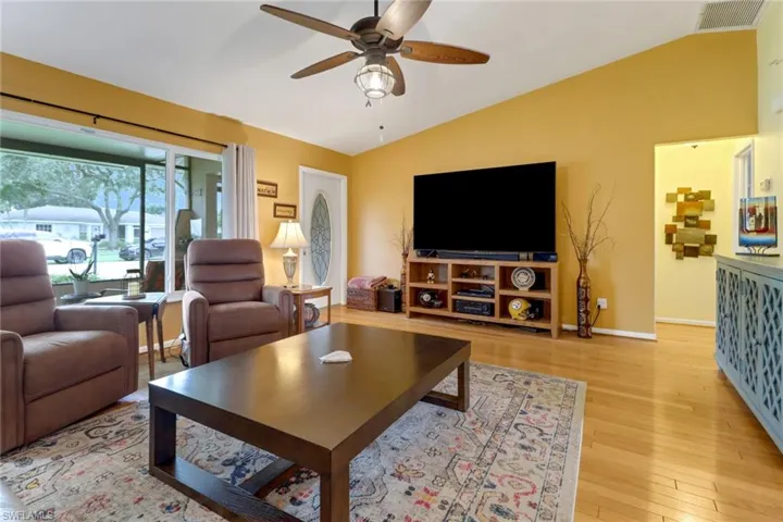 Living room featuring lofted ceiling, light hardwood / wood-style flooring, and ceiling fan