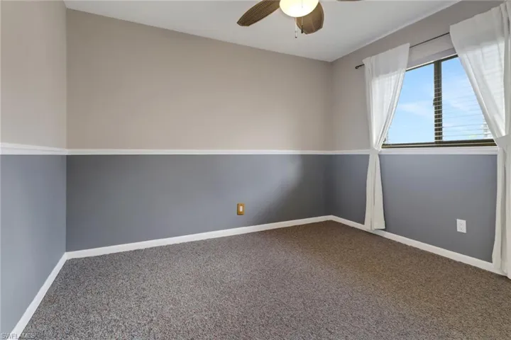 Carpeted empty room with ceiling fan