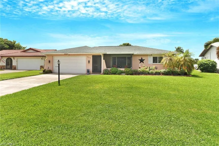 Ranch-style house featuring a garage and a front lawn