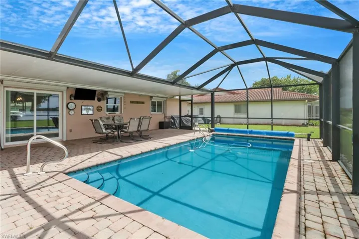 View of swimming pool featuring a lanai and a patio