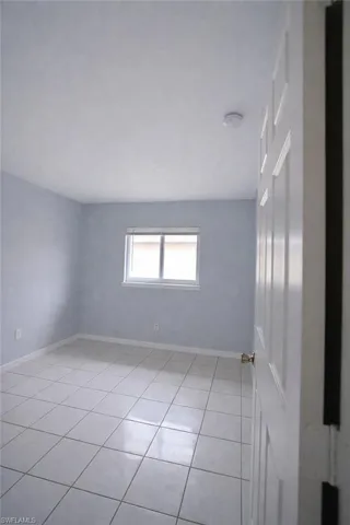 Spare room featuring baseboards and light tile patterned floors