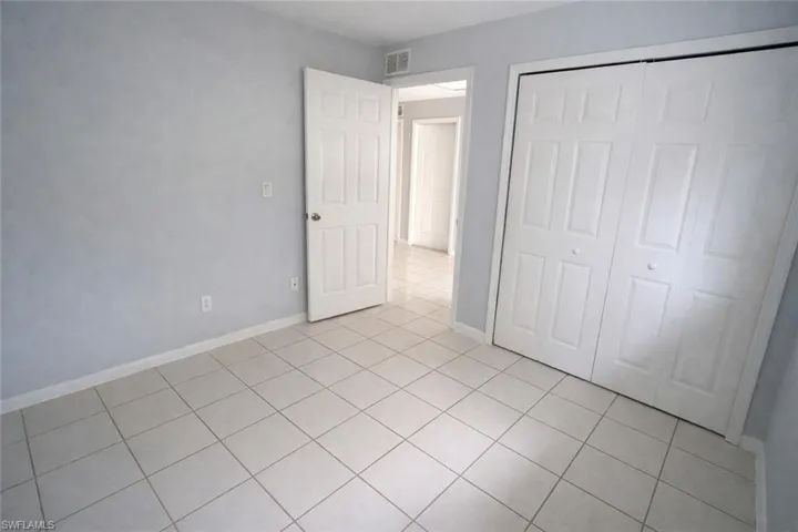 Unfurnished bedroom featuring light tile patterned floors and a closet