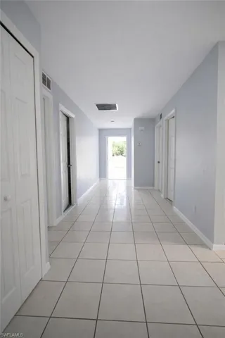 Hall with light tile patterned floors and baseboards