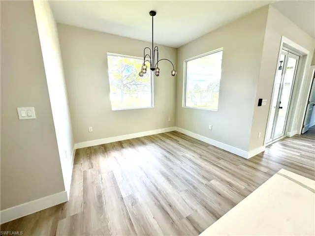 Spacious room featuring wood-finish flooring and two large windows