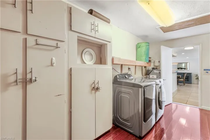 Laundry room featuring hardwood / wood-style flooring and washing machine and clothes dryer