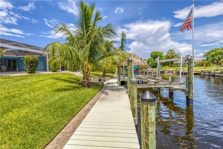 Dock area with a yard, a lanai, and a water view