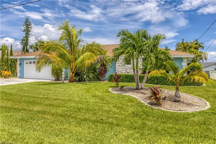 View of front of property with a garage and a front lawn
