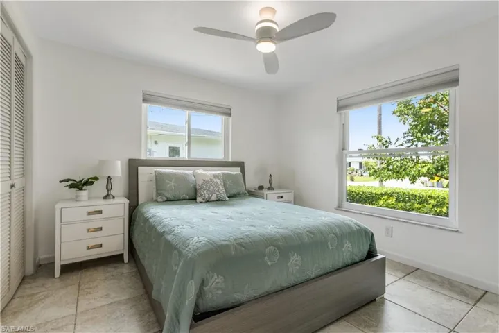 Tiled bedroom featuring a closet, ceiling fan, and multiple windows