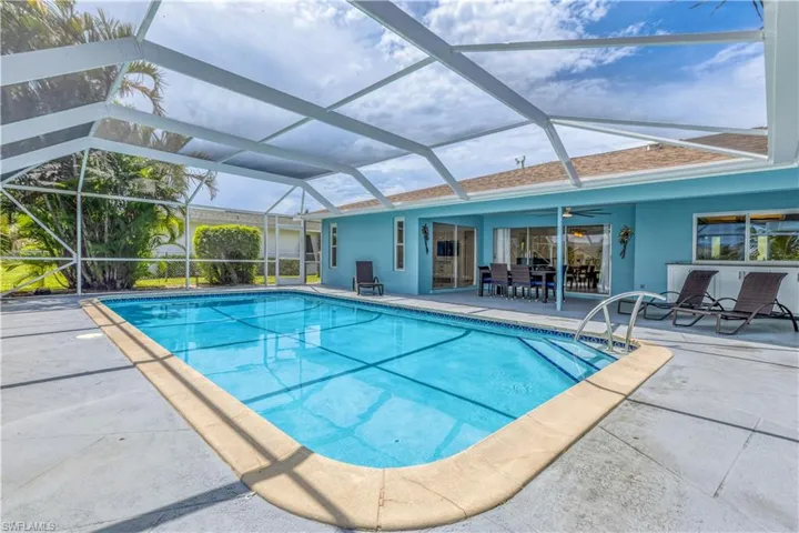 View of swimming pool featuring glass enclosure and a patio area