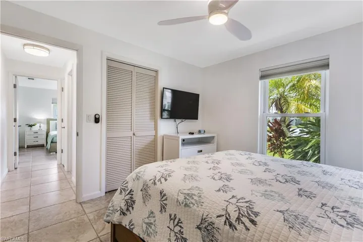 Tiled bedroom with a closet and ceiling fan