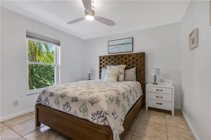 Bedroom with ceiling fan and light tile patterned flooring