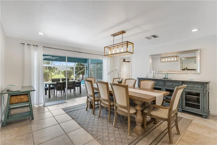 Dining area featuring light tile patterned flooring and ceiling fan with notable chandelier