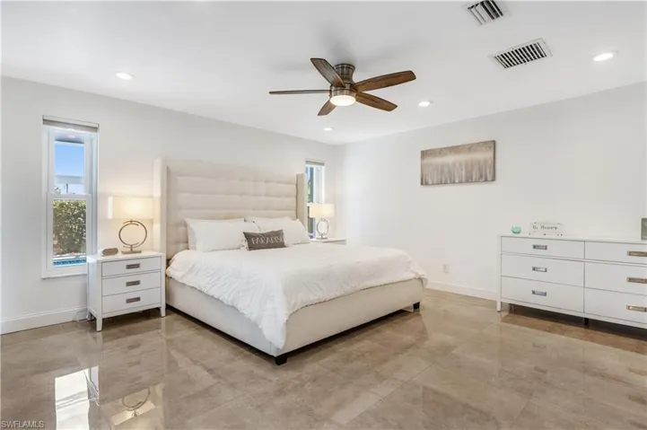 Tiled bedroom featuring ceiling fan