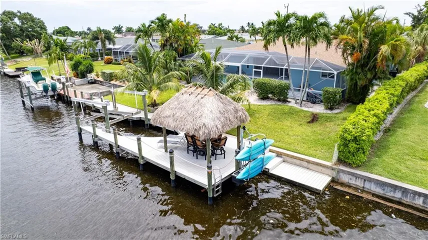 Dock area featuring a lawn, a lanai, and a water view