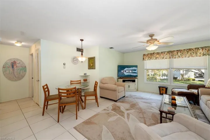 Living area with a ceiling fan and light tile floors