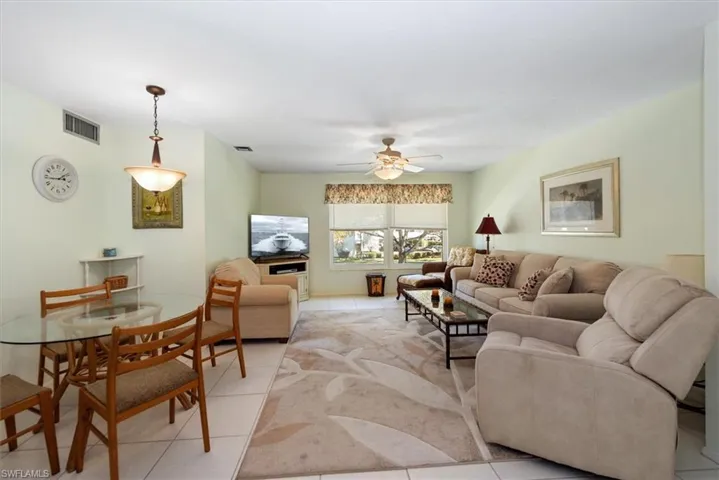 Living area featuring light tile patterned flooring and ceiling fan
