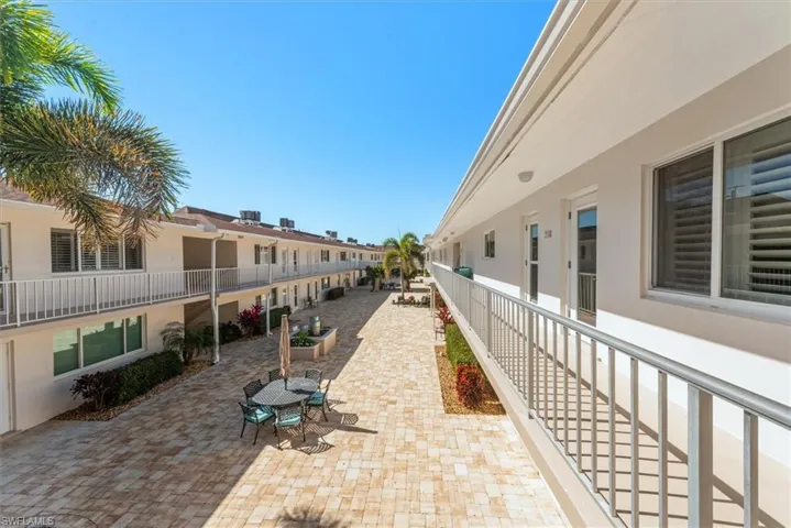 View of property's community with a paver patio area and outdoor dining area