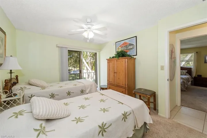 Bedroom featuring light colored carpet, access to balcony and ceiling fan
