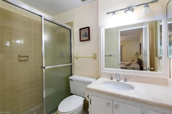 Full bath with a stall shower, vanity, and connected bathroom