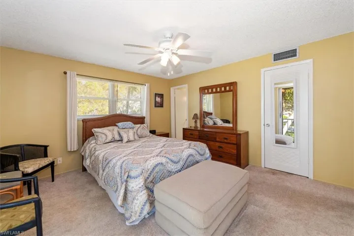 Bedroom with a ceiling fan, light carpet with access to balcony