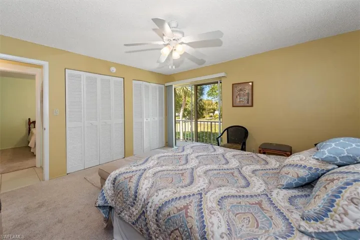 Bedroom with multiple closets, access to balcony, carpet, and ceiling fan