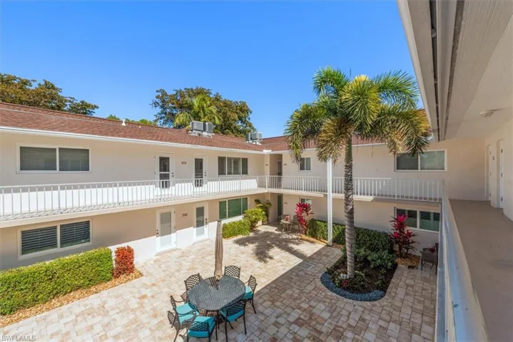 View of property's community featuring a balcony, outdoor dining space, and paver patio