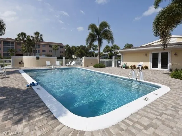Community pool featuring outdoor shower and a paver patio area