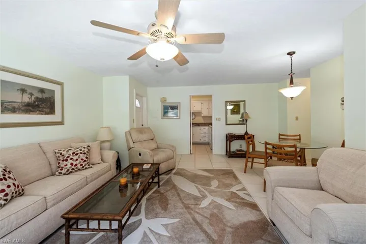 Living area with tile patterned floors and ceiling fan