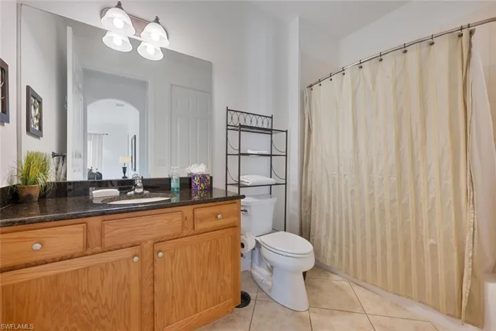Bathroom with vanity, light tile patterned flooring, and shower / bath combo